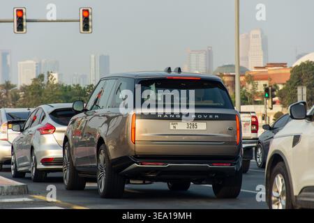 Vue arrière d'un SUV Range Rover gris de luxe attendant à un feu rouge dans la circulation urbaine à Dubaï, Émirats arabes Unis. Banque D'Images