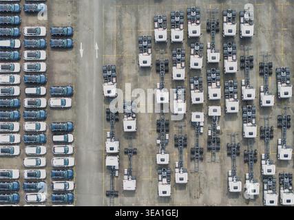 Vue aérienne de rangées organisées de voitures neuves et châssis de camion garés dans un grand parc de stockage de concessionnaire automobile Taiwan. Banque D'Images