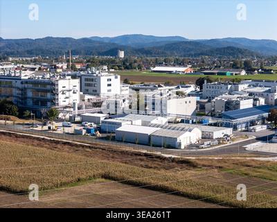 Une grande usine pharmaceutique avec des bâtiments de production et des unités de stockage dans une zone rurale près d'une petite ville. Banque D'Images