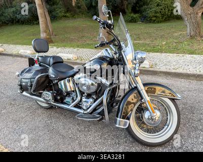Moto Harley-Davidson Heritage Softail Cruiser classique avec des accents chromés et des sacoches en cuir garées sur le bord de la route avec des pneus à flanc blanc Banque D'Images