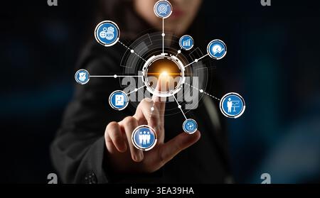 Un professionnel des affaires s'engage avec une interface tactile futuriste avec diverses icônes représentant la technologie, l'analyse de données et la modernité Banque D'Images