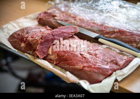 Longe de veau crue, préparation dans un restaurant pour le cours de viande d'un menu du dîner avec de nombreux invités, focus sélectionné, profondeur de champ étroite Banque D'Images