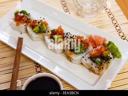 Rouleaux de sushi au crabe, concombre, saumon, avocat assaisonné de sauce unagi Banque D'Images