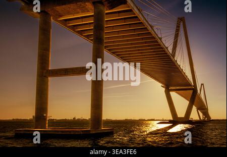Charleston, SC - US - 27 mars 2026 le coucher de soleil doré illumine le dessous de l'Arthur Ravenel Jr. Pont alors que ses supports imposants s'élèvent au-dessus de Rippli Banque D'Images