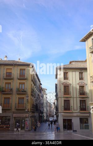 Piétons le long de la Calle Reyes Católicos bordée de façades ornées et de luminaires décoratifs en ferronnerie dans le centre historique de Grenade, Andalousie, Espagne. Banque D'Images