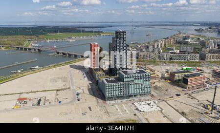 Vue aérienne du quartier moderne de Sluisbuurt avec ses tours résidentielles de grande hauteur, ses chantiers de construction et le pont Enneus Heerma sur la rivière IJ Banque D'Images