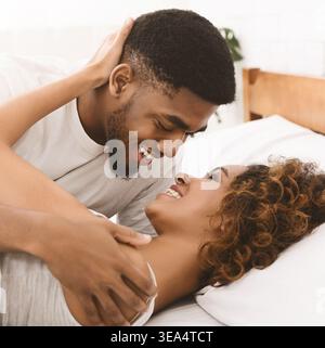 Amoureux couple noir se relaxant sur le lit à la maison, Banque D'Images