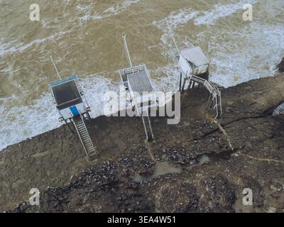 Vue aérienne des cabanes de pêche les carrelets le long du rivage rocheux avec des vagues s'écrasant, Saint-Palais-sur-mer, Charente-maritime, France. Banque D'Images