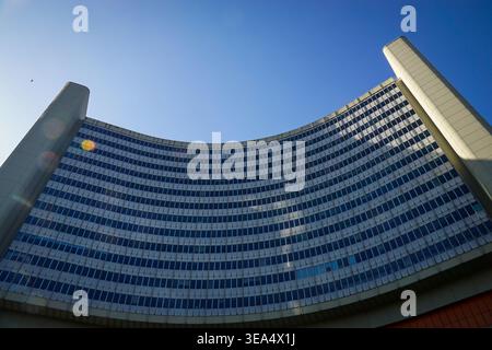 Immeuble de bureaux moderne incurvé avec façade en verre vue d'en bas contre le ciel bleu clair à Vienne, montrant une architecture symétrique haute et la lumière du soleil Banque D'Images