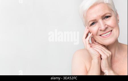 Exprimer la joie et la confiance avec un sourire chaleureux d'une femme mature aux cheveux blancs courts Banque D'Images