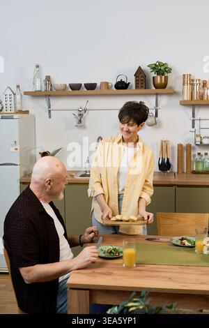 Couple senior apprécie un délicieux repas ensemble, célébrant leur amour et leur compagnie. Banque D'Images