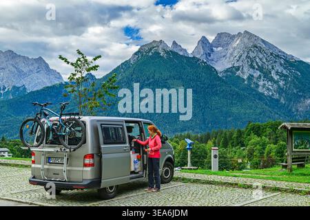 Femme debout devant le camping-car, Watzmann et Hochkalter montagnes en arrière-plan, Berchtesgaden Alpes, Berchtesgaden, haute-Bavière, Bavière, Banque D'Images