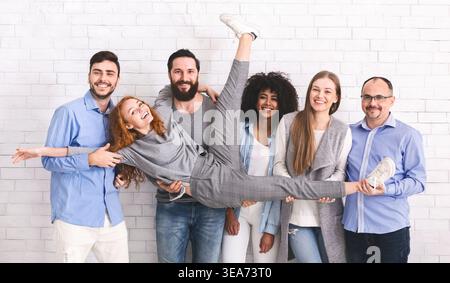 Groupe de personnes diverses tenant ami et posant Banque D'Images