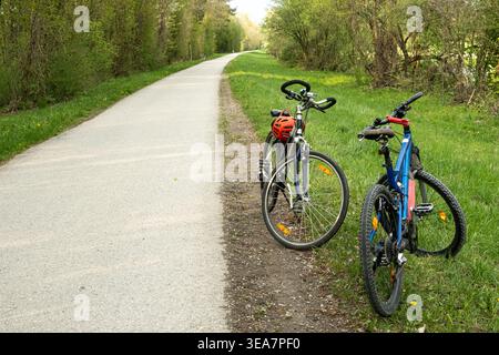 Deux vélos stationnés sur le côté d'une route asphaltée rurale. Banque D'Images