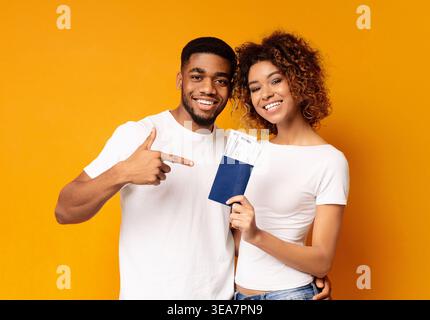 Happy young couple holding noire Passeports et billets Banque D'Images