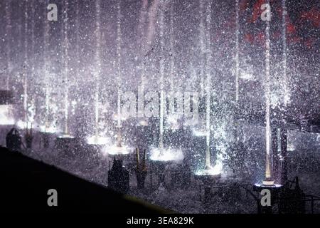 Fontaine d'eau avec jets éclairés et éclaboussures la nuit Banque D'Images