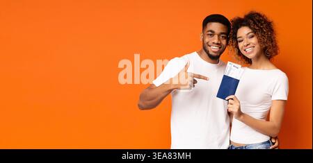Happy young couple holding noire Passeports et billets Banque D'Images