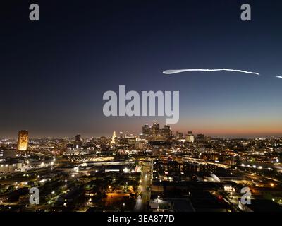 Un lancement de Falcon 9 laisse un panache de fusée dans le ciel au-dessus du centre-ville de Los Angeles après un lancement de SpaceX depuis Vandenberg Banque D'Images