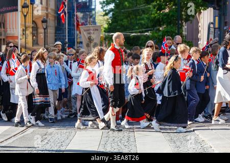 Oslo, Norvège - 17 mai 2025 : défilé traditionnel des enfants marquant le jour de la Constitution norvégienne, avec des écoliers en bunad et en tenue formelle agitant natio Banque D'Images