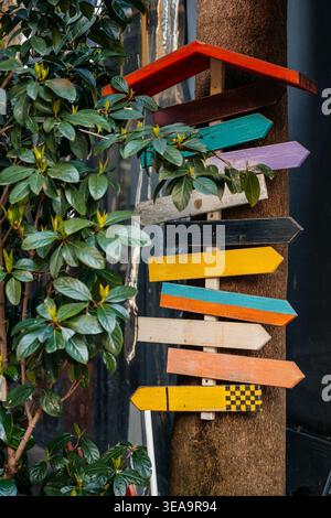 Indicateurs fléchés peints de couleurs vives. Panneaux décoratifs peints avec charme extérieur ludique Banque D'Images
