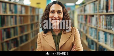 Éducation, portrait ou enseignant en bibliothèque avec les bras croisés, emploi ou confiance en position académique. Femme heureuse, mature ou éducatrice à l'école avec Banque D'Images