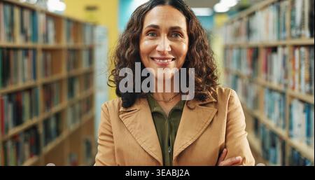 Éducation, portrait ou enseignant en bibliothèque avec fierté, emploi ou confiance en position académique. Femme heureuse, mature ou éducatrice à l'école avec Banque D'Images