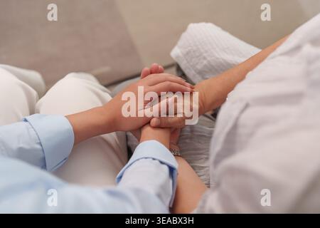 Fille asiatique tenant les mains de la mère aînée, montrant soins et soutien Banque D'Images
