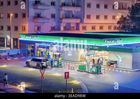 9 janvier 2026, Dubaï, Émirats arabes Unis : station-service Emarat la nuit avec ravitaillement en SUV, paysage urbain illuminé à Dubaï mettant en valeur la commodité et la moder Banque D'Images