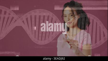 Tenant le ruban rose, femme en tee-shirt rose clair regardant dans le studio avec l'ADN et les données de code-barres, copiez l'espace Banque D'Images