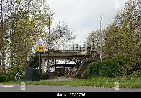 Station de métro Hadrian Road située dans le quartier Wallsend de Newcastle, à Tyne et Wear. La station est positionnée le long des rives nord de la Tyne. La structure comporte une plate-forme surélevée accessible par des escaliers. Des arbres verts entourent la zone, indiquant la présence de parcs ou d'espaces naturels à proximité. Banque D'Images