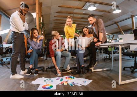 L'équipe collabore dans Creative Workspace pour développer une stratégie marketing avec des présentations colorées Banque D'Images