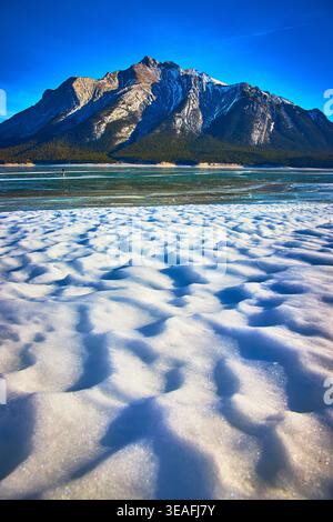 Dunes de neige sur le lac gelé avec Majestic Mountain sous ciel d'hiver clair Banque D'Images