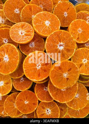Gros plan pile de tranches pelées de mandarine orange à la texture juteuse Banque D'Images