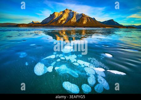Bulles de glace gelées du lac et reflets majestueux des montagnes en hiver Banque D'Images