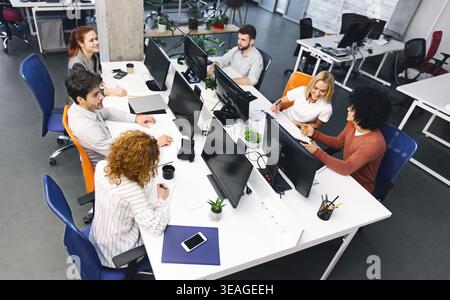 Groupe de jeunes gens divers discuter sur le lieu de travail du projet Banque D'Images