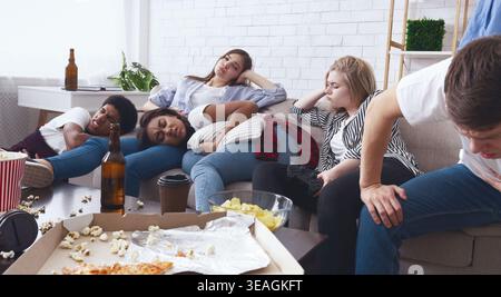 Groupe d'amis se relaxant et dégustant des collations pendant une soirée cinéma à la maison Banque D'Images
