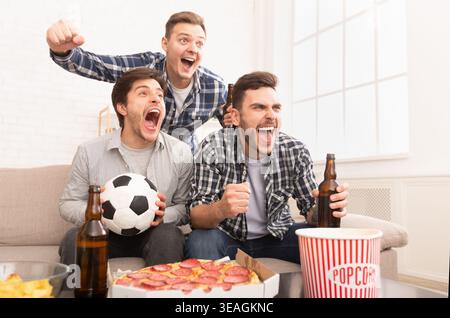 Amis appréciant le sport avec des collations et des boissons à la maison Banque D'Images