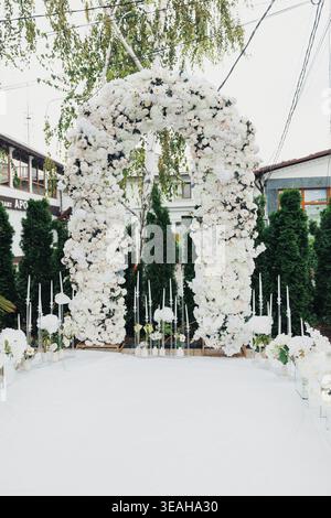 Arche décorative somptueuse avec fleurs blanches vives et création de feuillage verdoyant. Cadre floral exquis avec des fleurs blanches luxuriantes et de la verdure Banque D'Images