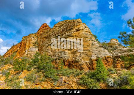 Vue spectaculaire vers le haut des formations rocheuses de grès érodées massives avec des couches complexes sous un ciel bleu vif dans le parc national de Zion. Banque D'Images