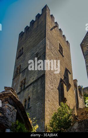 Une vue éditoriale détaillée sous angle bas de la tour défensive massive en pierre du Château de Beynac. L'image met en valeur l'arc historique en calcaire doré Banque D'Images