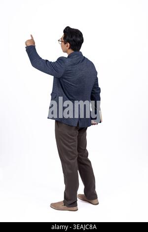 Jeune homme debout, dos à la caméra et pointant vers le haut Banque D'Images