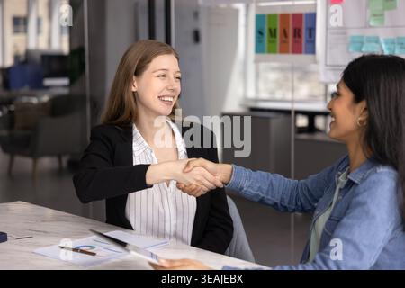 Deux jeunes femmes d'affaires professionnelles des années 30 se serrant la main Banque D'Images