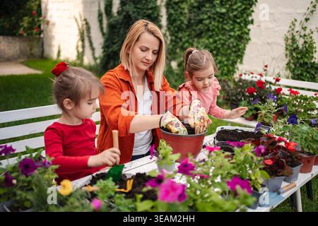 Jardinage ensemble dans la cour ensoleillée avec les enfants Banque D'Images