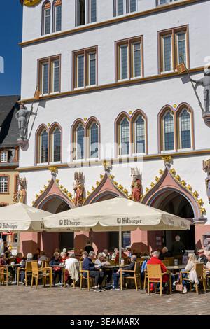 Trèves, Allemagne - 14 avril 2026 : des personnes assises à des tables dans un café-bar dans un vieux bâtiment richement décoré par une journée ensoleillée dans le centre commercial de Banque D'Images