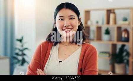 Heureux, confiance et portrait de femme asiatique à la maison avec attitude positive, bonne humeur et sourire. Propriétaire, appartement et personne dans le salon pour Banque D'Images