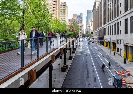 La High Line à Manhattan, New York City, au printemps avec des visiteurs marchant sous des arbres verts dans le parc linéaire, la voie verte urbaine ou le chemin de fer Banque D'Images