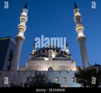 Mosquée de Namazgah à Tirana avec minarets illuminés et dôme contre un ciel nocturne bleu profond. Banque D'Images