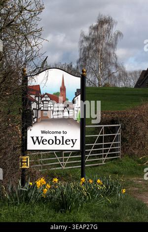 Bienvenue à Weobley, panneau du village, Hereforshire, Royaume-Uni. Avec des jonquilles à floraison printanière. Banque D'Images