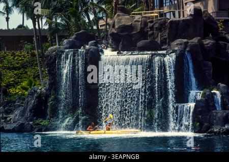 Les clients Hoterl pagayent à travers une cascade artificielle dans un hôtel haut de gamme sur l'île de Maui, Hawaï, États-Unis Banque D'Images