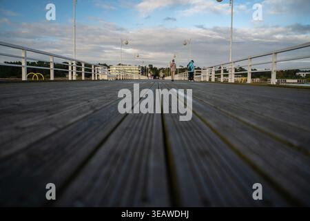 Vue en angle bas des gens marchant sur une jetée en bois près de la mer Baltique polonaise. Photo de haute qualité Banque D'Images